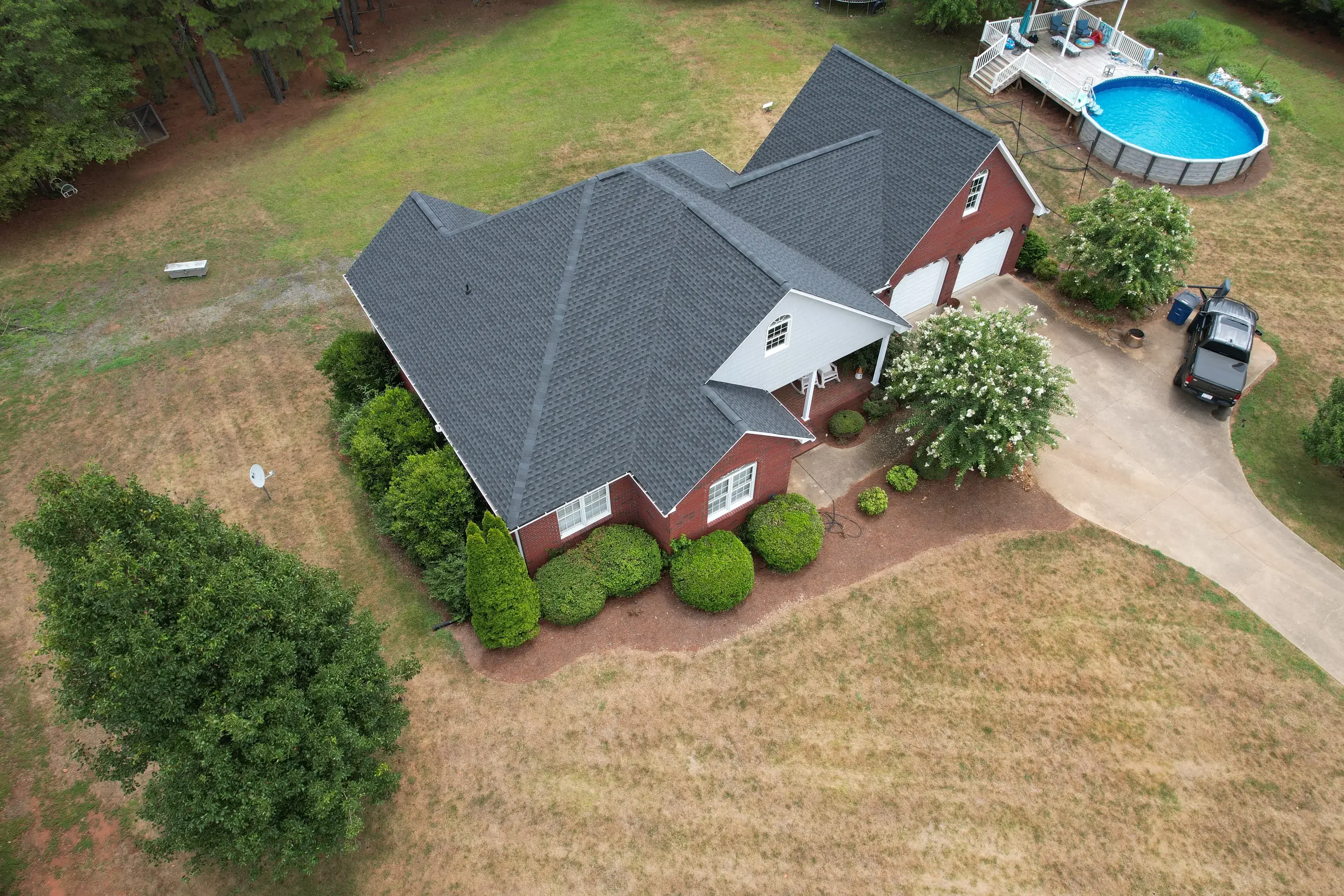 Aerial view of red brick home with new charcoal gray architectural shingle roof in Shelby, NC