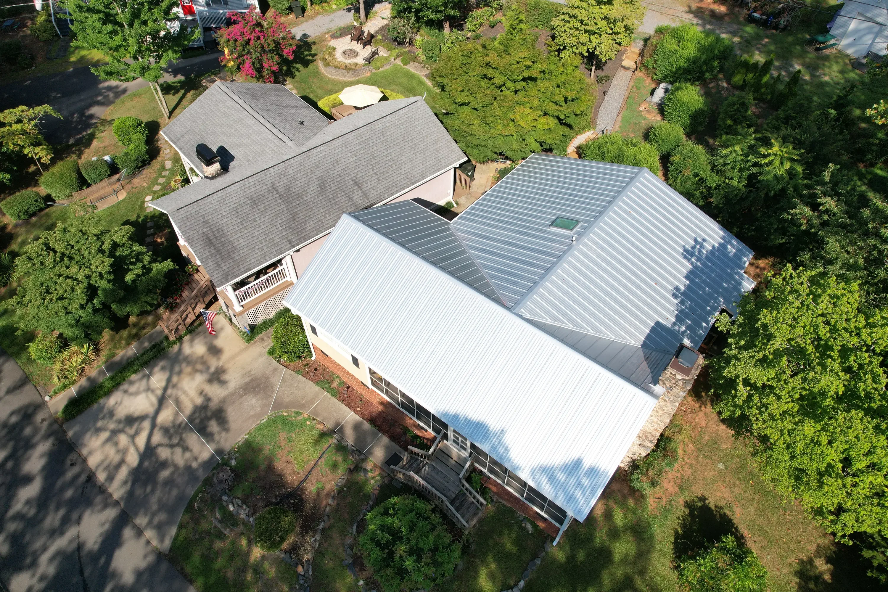 Aerial view of residential home with new architectural shingle and metal roofing installation in Shelby