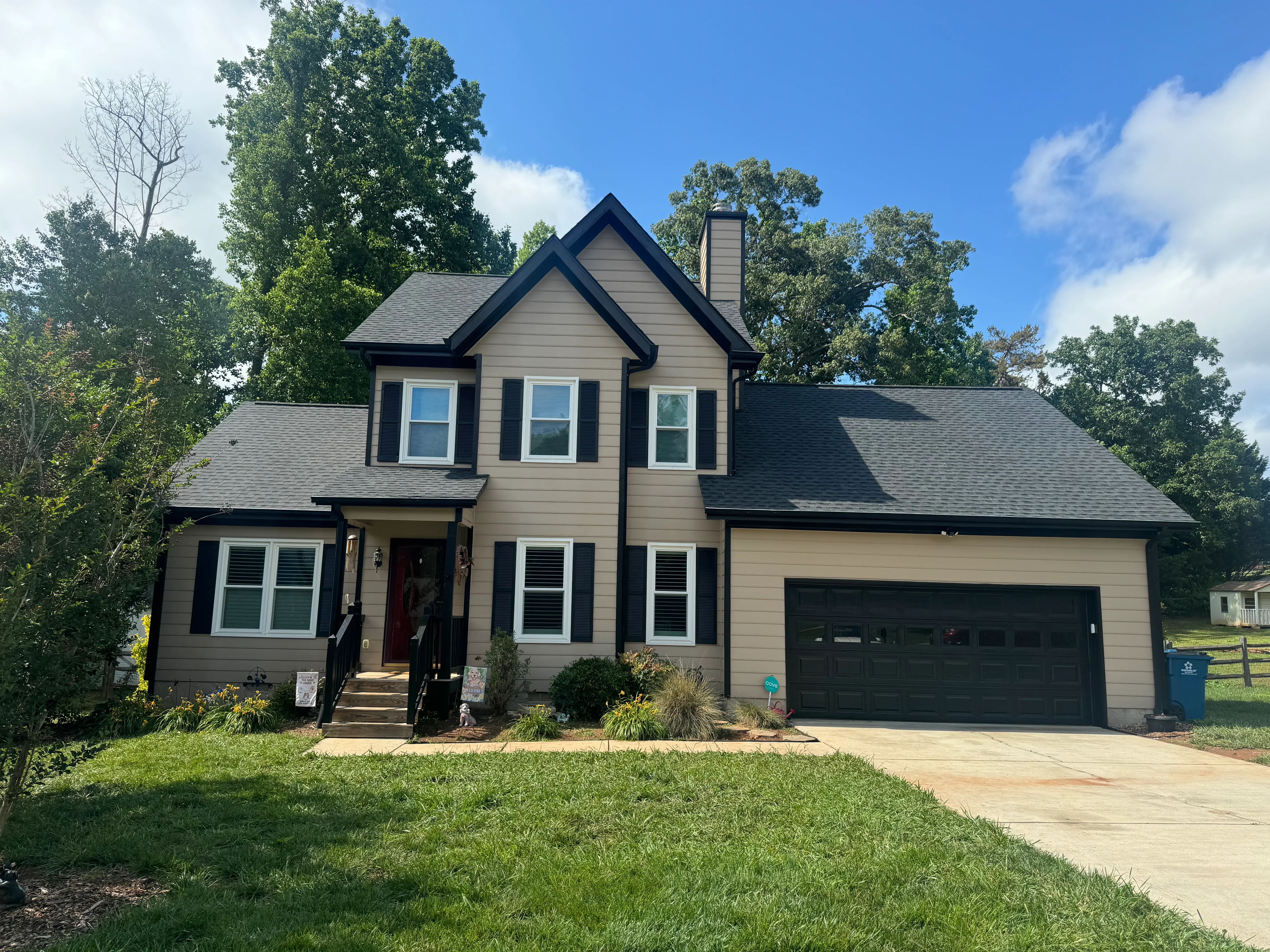 Two-story home with new charcoal gray asphalt shingle roof and black shutters